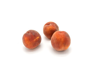 Ripe peaches on a white background. Three pink-orange fruits isolated.