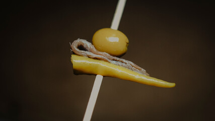 Photo of one of the most iconic Spanish pintxos called Gilda, which consists  of pepper, olive and anchovie skewers