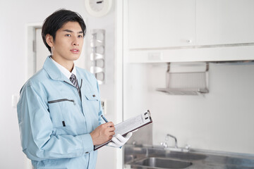 部屋の設備チェックをする日本人男性作業員