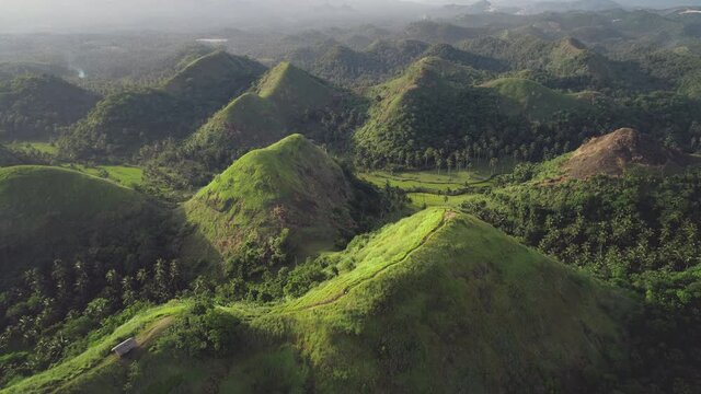 Mountains landscape aerial: building on top of mount with hiking path. Majestic Asia wild nature scenery at Legazpi countryside. Philippines landmark for tourist adventure at tropical forest hills