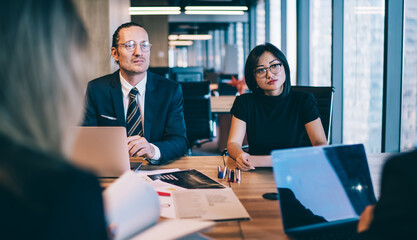 Focused diverse business people negotiating with partners in office