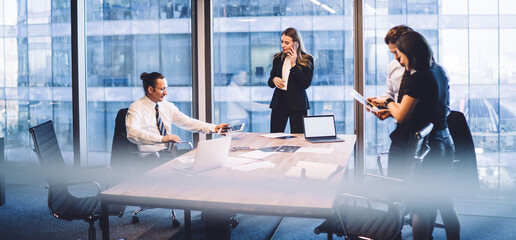 Confident business people using gadgets during meeting