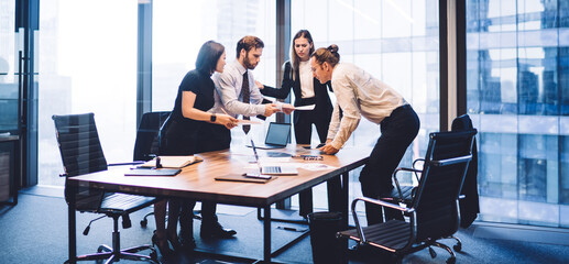 Multiethnic business people reading documents together in boardroom