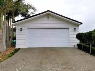 Modern white garage door separate from the house