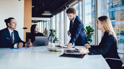 Modern executive male and diverse colleagues at desk in office