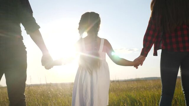 happy family parent hold holding kid daughter hand. mother and girl kid together hands at sunset. parent girl and child kid hold hands dream concept. happy family mother day concept fun