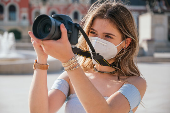 Tourist woman wearing mask and taking pictures