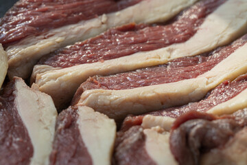 Pedaços de picanha fatiados e preparados para churrasco. 