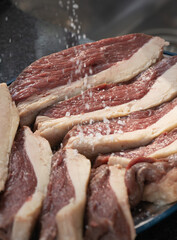 Pedaços de picanha fatiados e preparados para churrasco. 