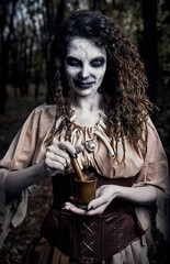 Halloween theme: creepy dismal voodoo witch with mortar and pestle. Portrait of evil sorceress in...