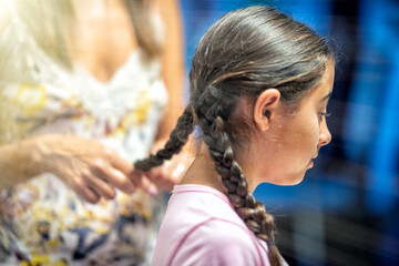 Woman combing her daughter's hair at home before school