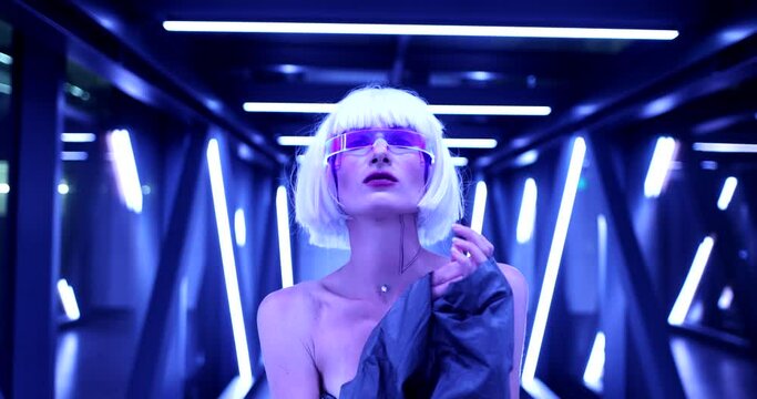 Blonde in blue neon and futuristic clothes. Cyberpunk and the fashion of the future