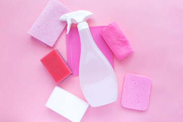 Cleaning products agent, sponges, napkins and rubber gloves, pink background. Top view