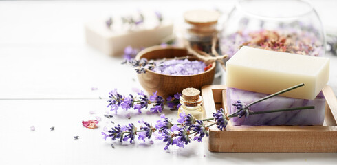 Lavender's soap and Spa products with lavender flowers on a white table.