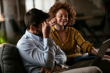 Fototapeta premium Colleagues sitting and talkig in office. Businesswoman and businessman discussing work in office...