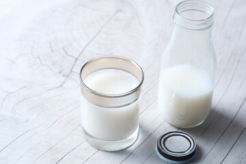 Close up of glass of milk and jar on table 