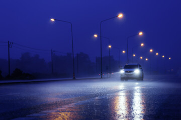 Wet road with light reflections,.twilight scene during hard rain fall.Selective focus with shallow depth of field.