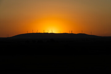 Red sky and sunset windmills silhouette.