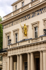 Street scene in the central London: Neoclassical style Athenaeum building (1824) at 107 Pall Mall at the corner of Waterloo Place. London, England, UK.
