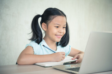 Asian girl student online learning class study online video call zoom teacher, Happy girl learn online with laptop at home.New normal. Covid-19 coronavirus, Social distancing, education anywhere.