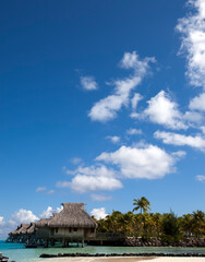 Fototapeta na wymiar Morning on the tropical island landscape - huts on piles, the sea..