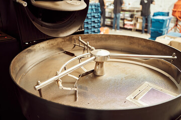 Coffee roasting machine with workers on background