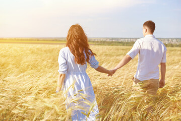 The concept of love, good relationships, understanding and harmony. Lovely young couple is walking in nature holding hands