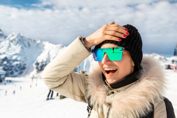 Portrait of beautiful young adult caucasian woman in sport suit, hat, sunglasses smiling looking...