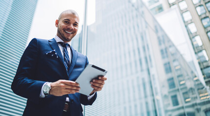 Excited businessman using tablet in downtown