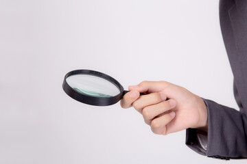 Closeup young asian business man in suit look magnifying glass for search isolated on white background, businessman expression and find quality, inspector and scrutiny, male expression.