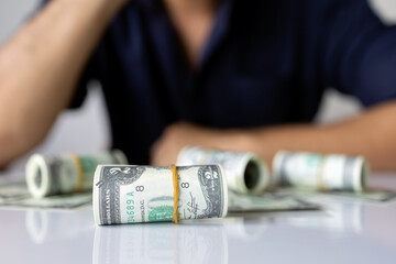 closeup hands holding us dollar bills with soft-focus and over light in the background