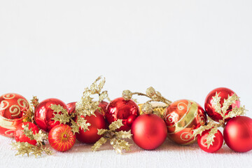 Closeup of red Christmas balls and golden branches on white background. Selective focus, copyspace,...