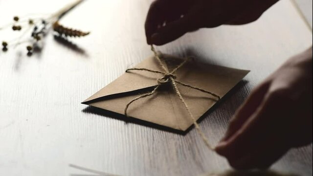 Womens hands  open kraft envelope on wooden  background