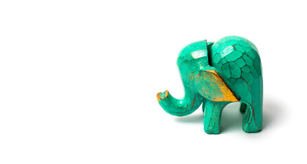 Figurine of a green wooden elephant with gilding isolated on white background. Decorative figurine of an elephant, hand carved wooden model of an elephant. Statuette, toy, souvenir from Asia