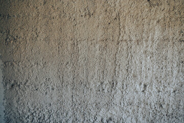 Empty wall covered with a layer of cement mortar, grungy gray background.