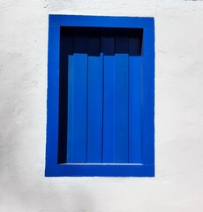 Rustic house with blue wooden retro window.