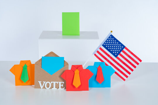 Presidential elections in the United States. Origami men near the ballot box and the American flag. Americans are choosing a President in 2020. A vivid concept of the Presidential election in USA.