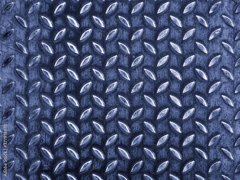 Poster metal surface are embossed with shapes that look like leaves. the leaves are arranged in lines and p