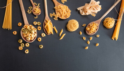 Pasta assortment on black background, top view. Cooking italian cuisine concept