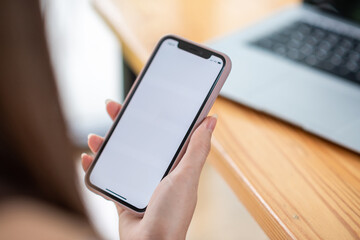 Mock up. image of woman holding mobile phone with blank white screen.