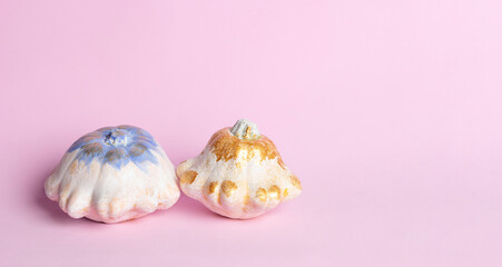 White and gold pumpkins - Halloween decoration on pink background. Thanksgiving composition on Modern autumn styled. Trendy holiday concept.