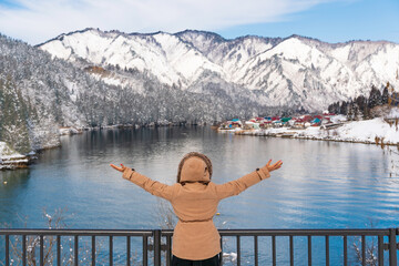 Young Asian woman relax at snowy mountains landscape, Tadami railway.