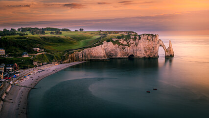 Beautiful sunset over calm sea and cliffs, Etetrat chalk cliffs, France