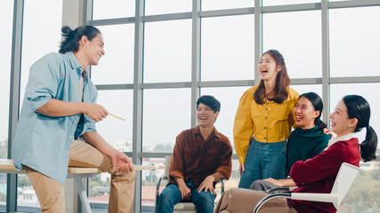 Group of young college students in smart casual wear on campus. Friends brainstorming meeting talking and discussing work ideas new design project in modern office. Coworker teamwork, startup concept. © tirachard