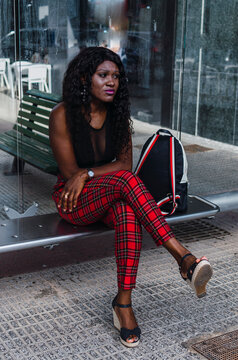 African girl waiting at the bus stop in Spain to go to work