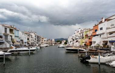 Fototapeta na wymiar beautiful canal side houses with moored boats on a cloudy day