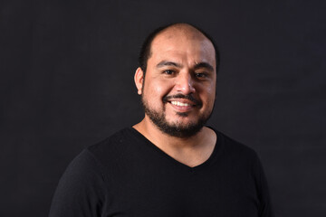 portrait of a latin american man on black  background,smiling