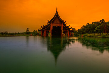 The background of the Wat Pa Kham Charoen is a beautiful old church with a Buddhist statue and a...