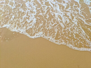 yellow sand beach with white waves running