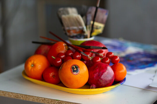 still life with fruits and paint brushes